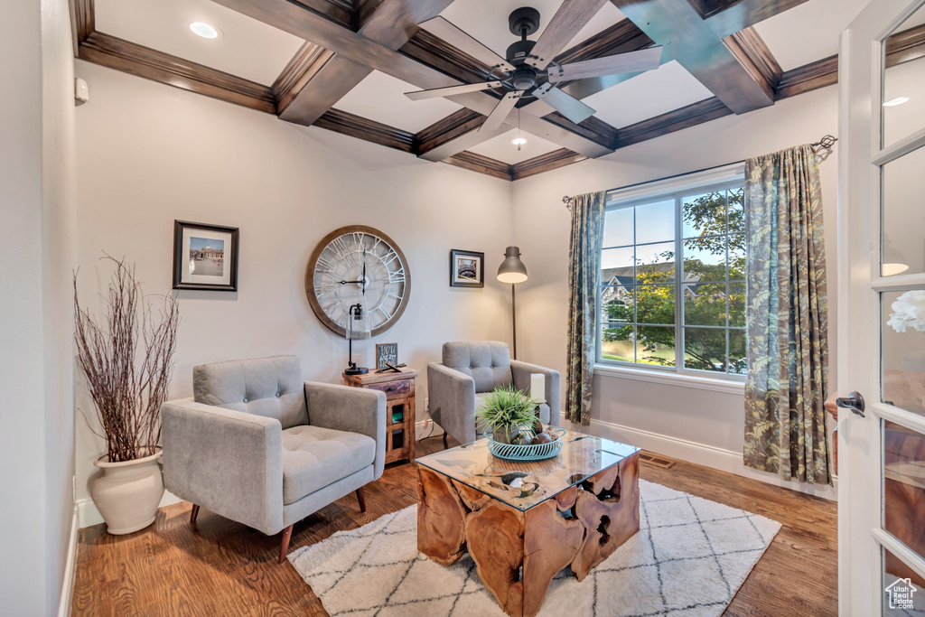 Sitting room with coffered ceiling, beamed ceiling, light wood-type flooring, ceiling fan, and ornamental molding