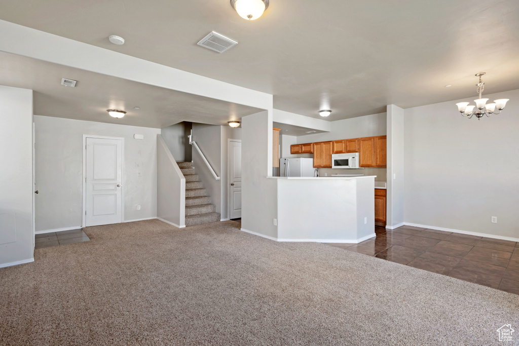 Interior space featuring dark carpet and a chandelier