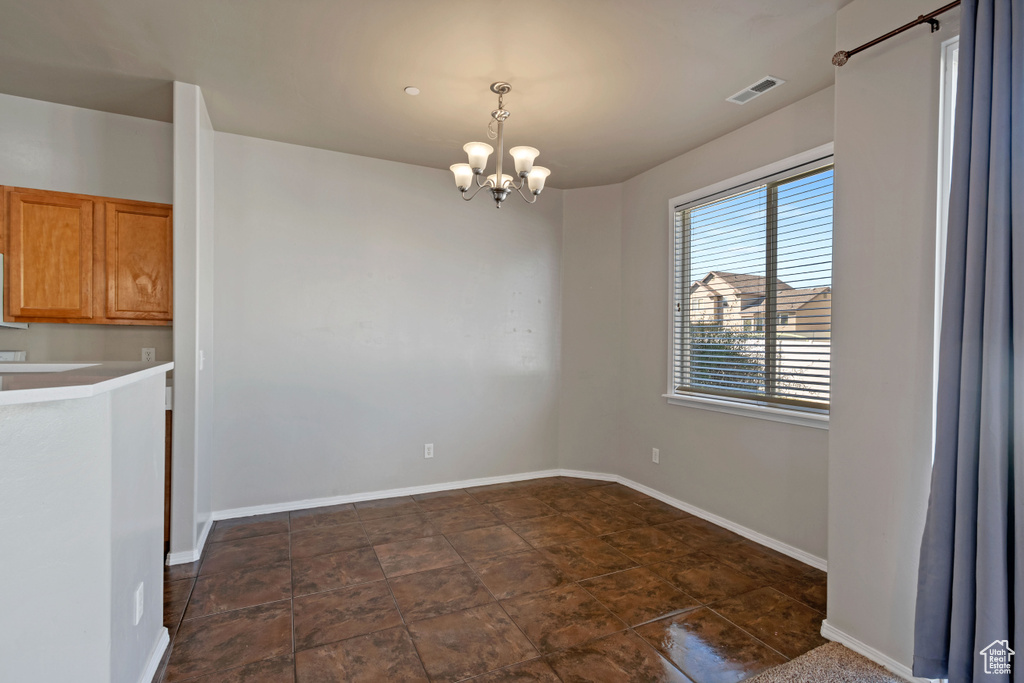 Unfurnished dining area featuring a notable chandelier