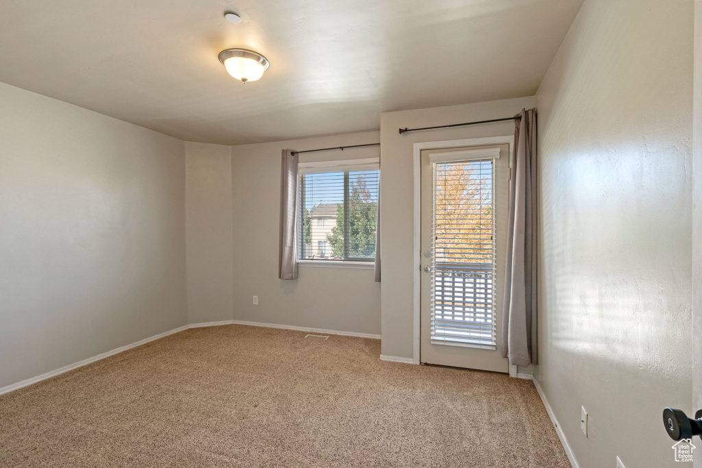 Unfurnished room featuring light carpet