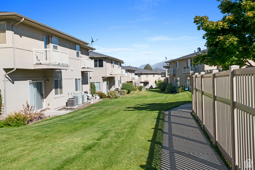 View of yard with a balcony and central AC unit