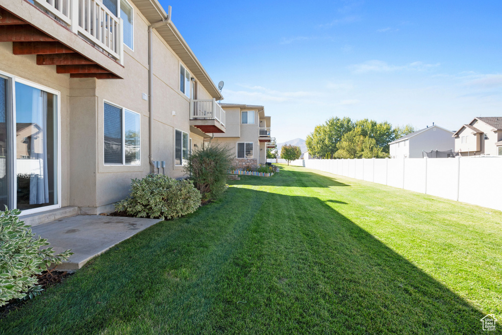 View of yard featuring a balcony and a patio