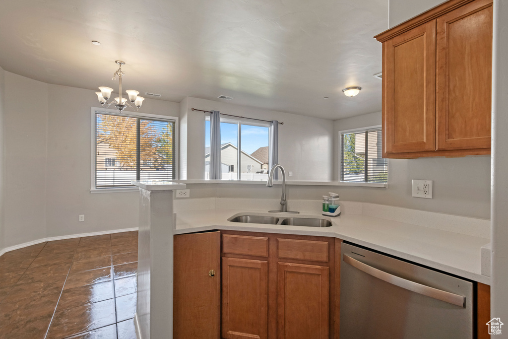 Kitchen featuring kitchen peninsula, tile patterned flooring, an inviting chandelier, stainless steel dishwasher, and sink