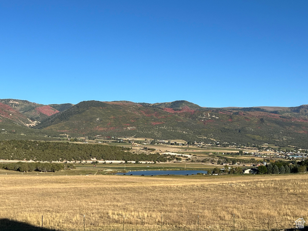 Property view of mountains featuring a water view and a rural view