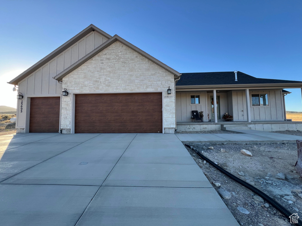 View of front of house featuring a porch and a garage