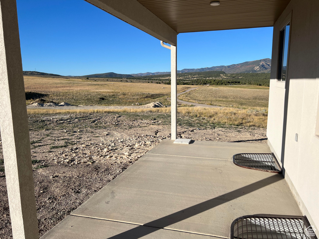 View of patio / terrace featuring a mountain view and a rural view