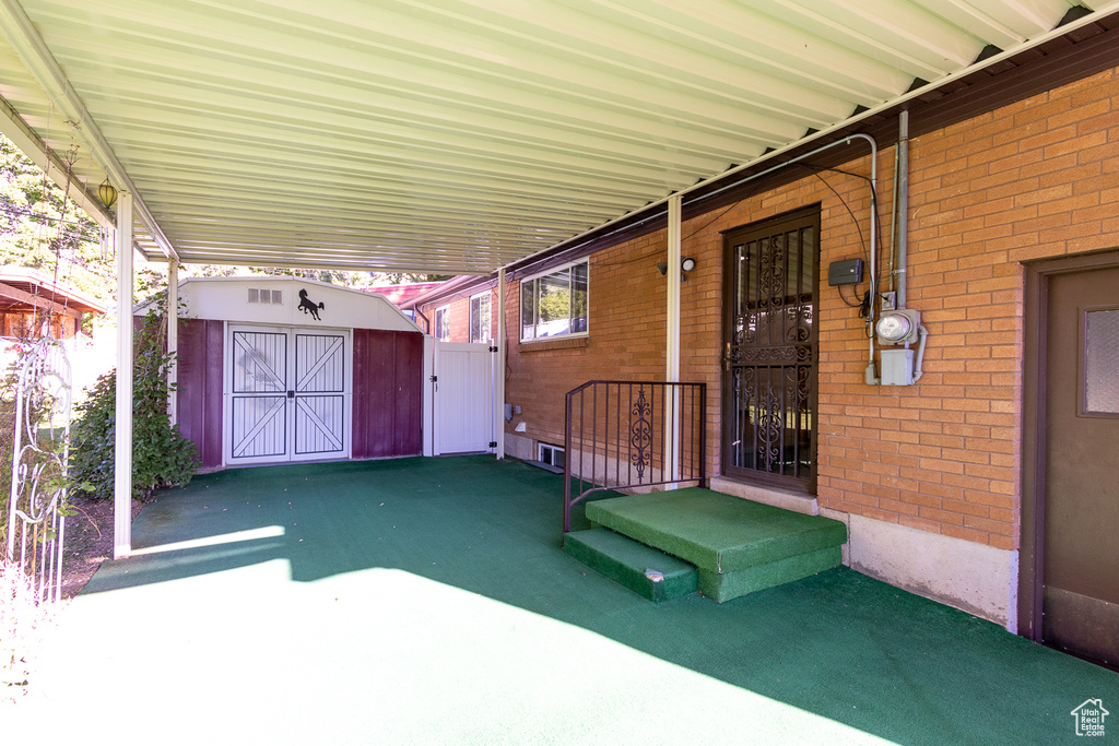 View of patio with a storage unit