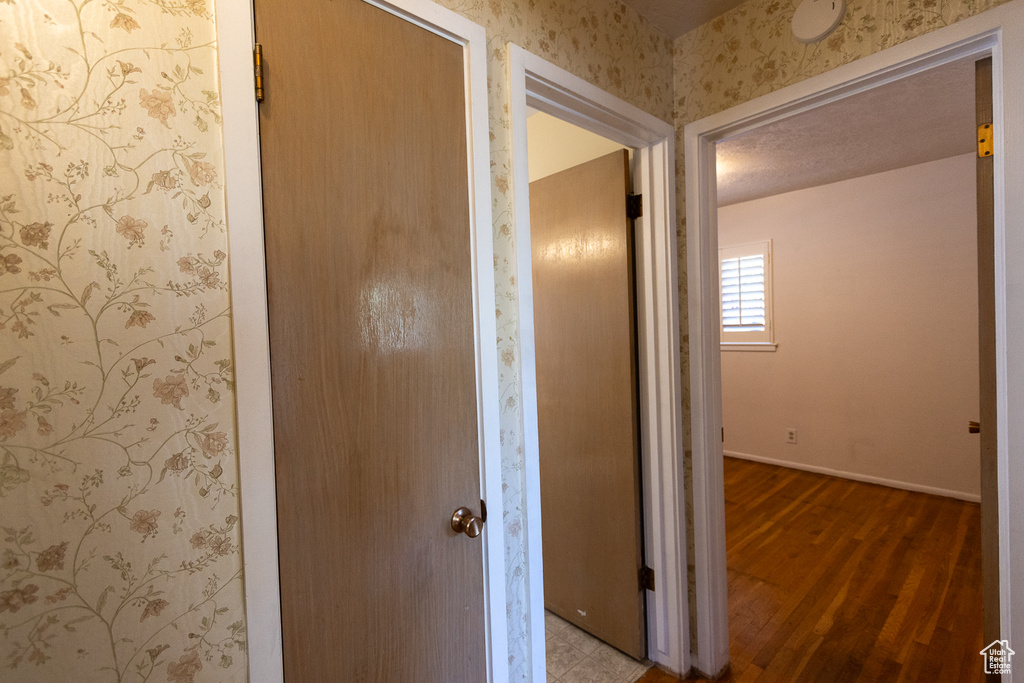 Hall with wood-type flooring and a textured ceiling