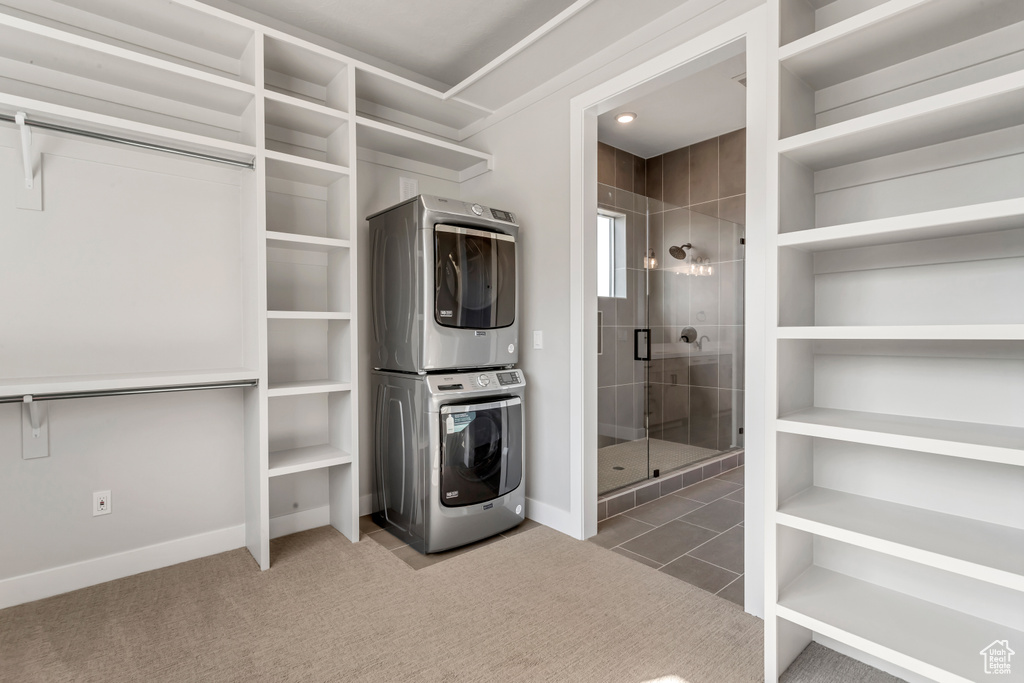 Washroom with carpet flooring and stacked washer and clothes dryer