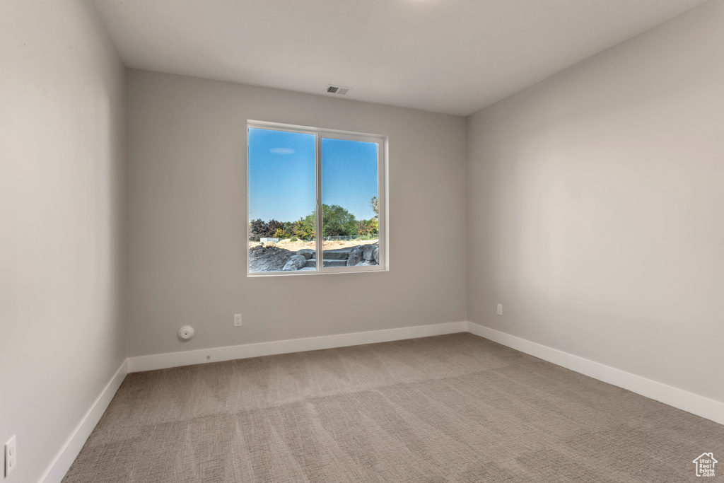 Empty room featuring light colored carpet