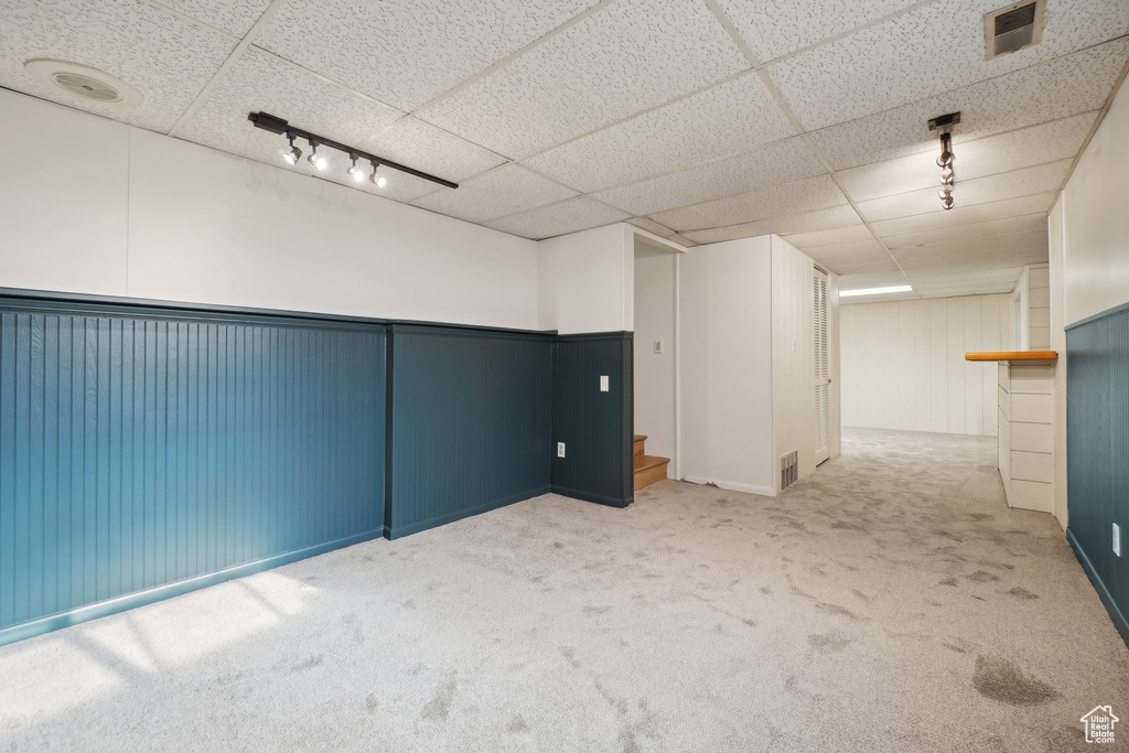 Interior space featuring rail lighting, carpet flooring, and a paneled ceiling