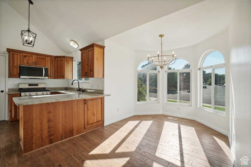 Kitchen featuring pendant lighting, an inviting chandelier, hardwood / wood-style floors, and white gas stove