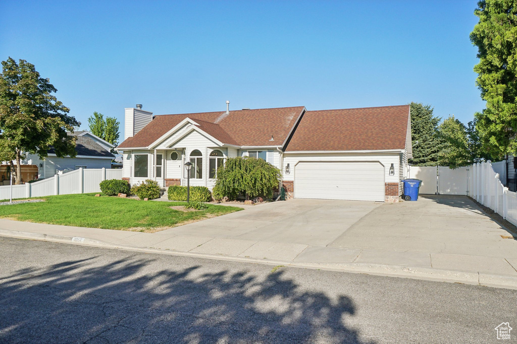 View of front of house featuring a front lawn and a garage