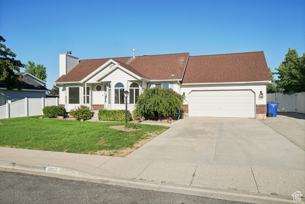 View of front of property with a garage and a front yard