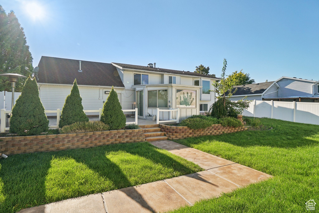 View of front of house with a patio and a front lawn