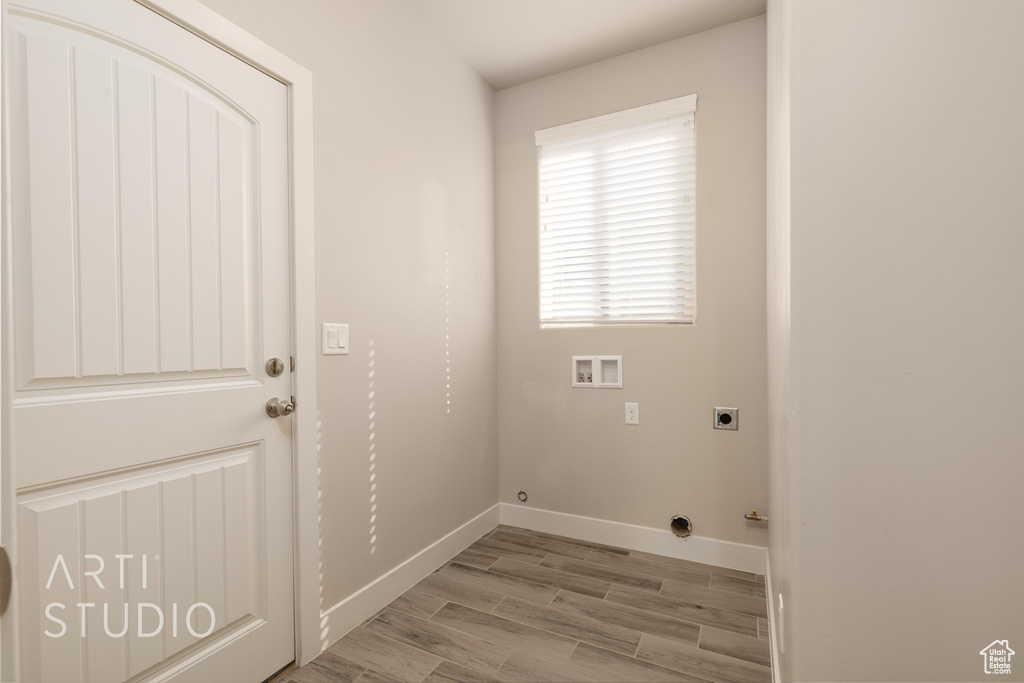 Clothes washing area featuring washer hookup, hookup for an electric dryer, light hardwood / wood-style floors, and gas dryer hookup