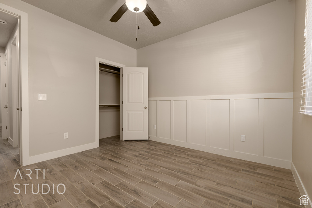 Unfurnished bedroom with light hardwood / wood-style floors, ceiling fan, and a closet