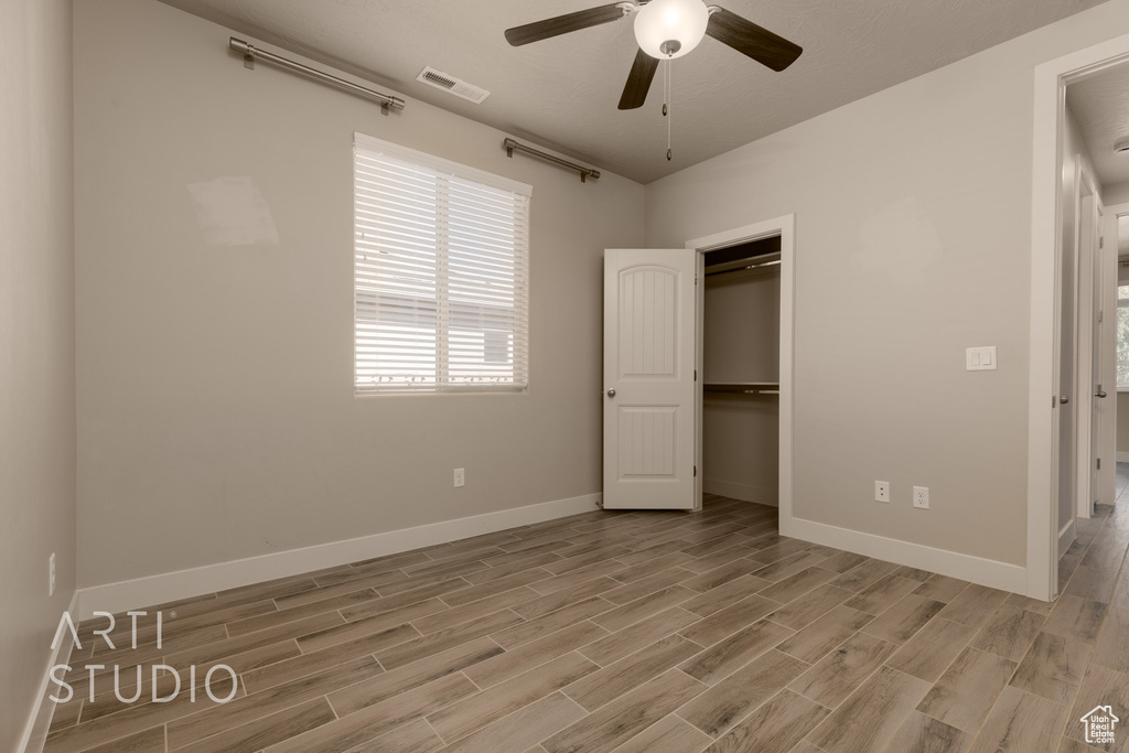 Unfurnished bedroom with ceiling fan, a closet, and light hardwood / wood-style floors