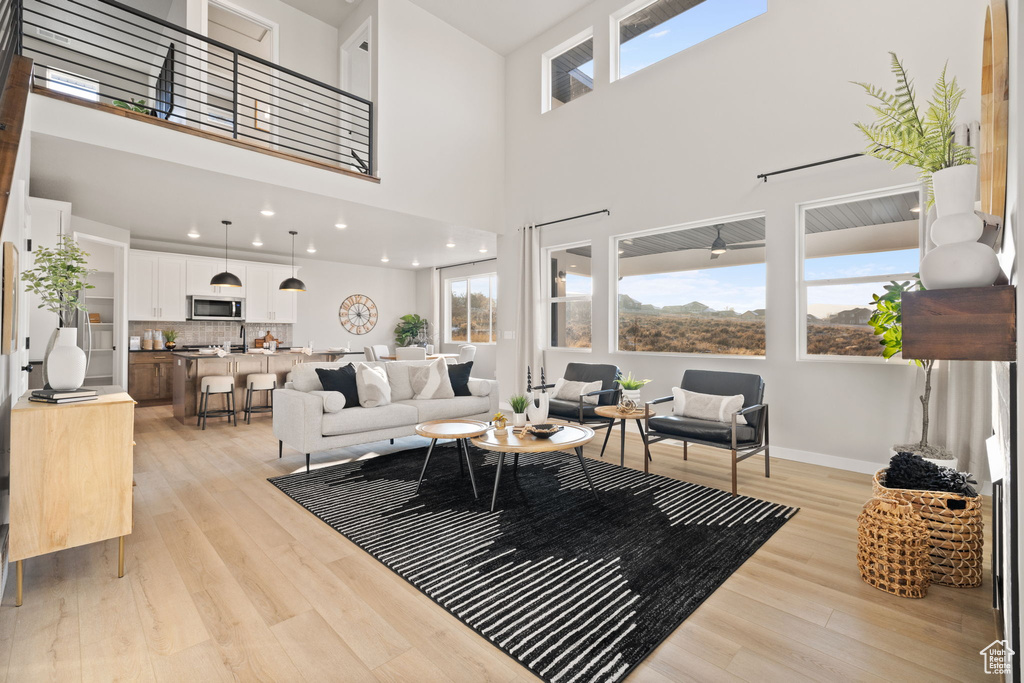 Living room with a high ceiling and light wood-type flooring