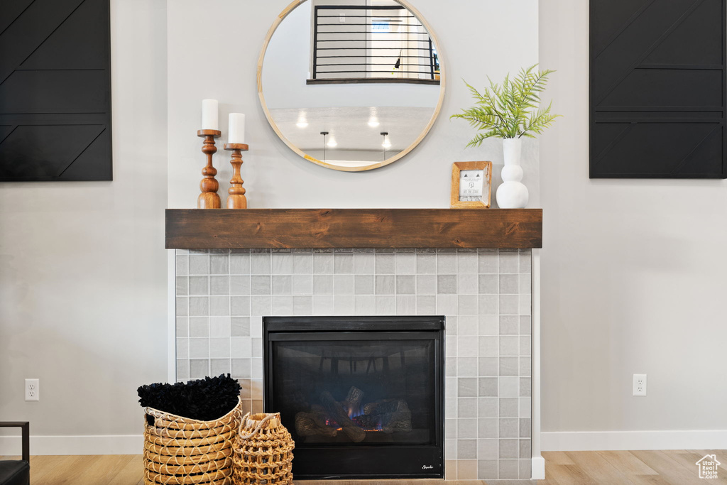 Details featuring wood-type flooring and a tiled fireplace