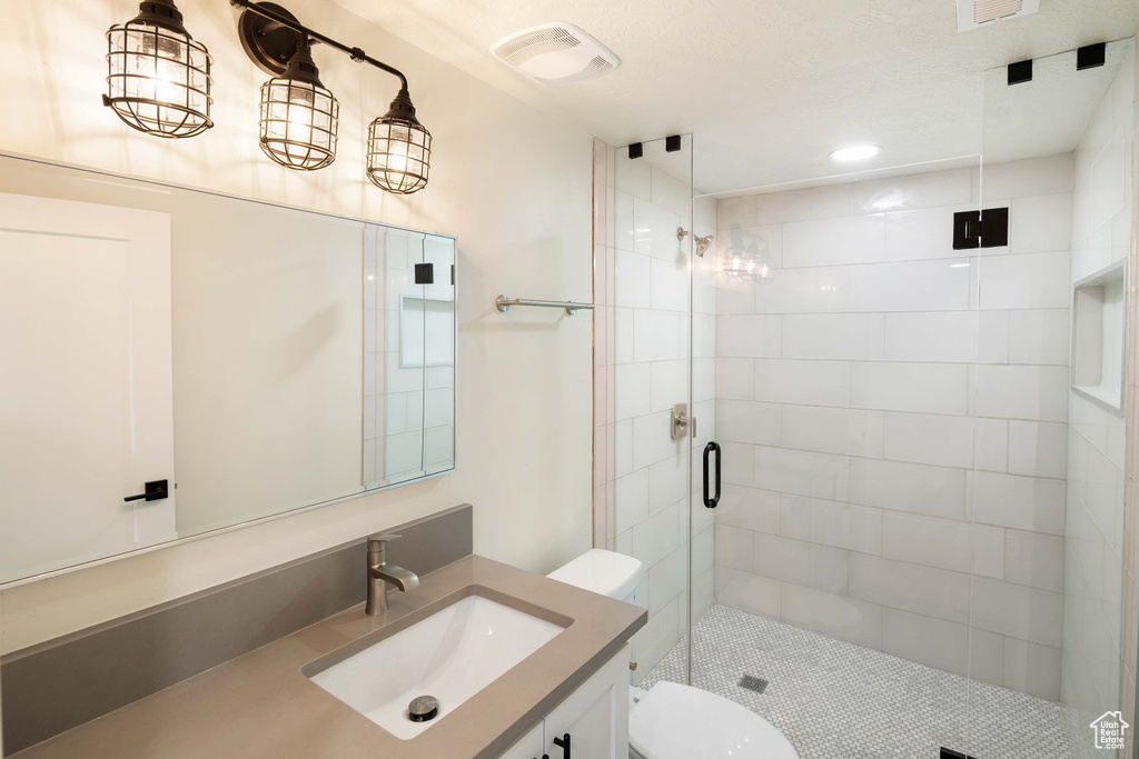 Bathroom with walk in shower, vanity, and toilet