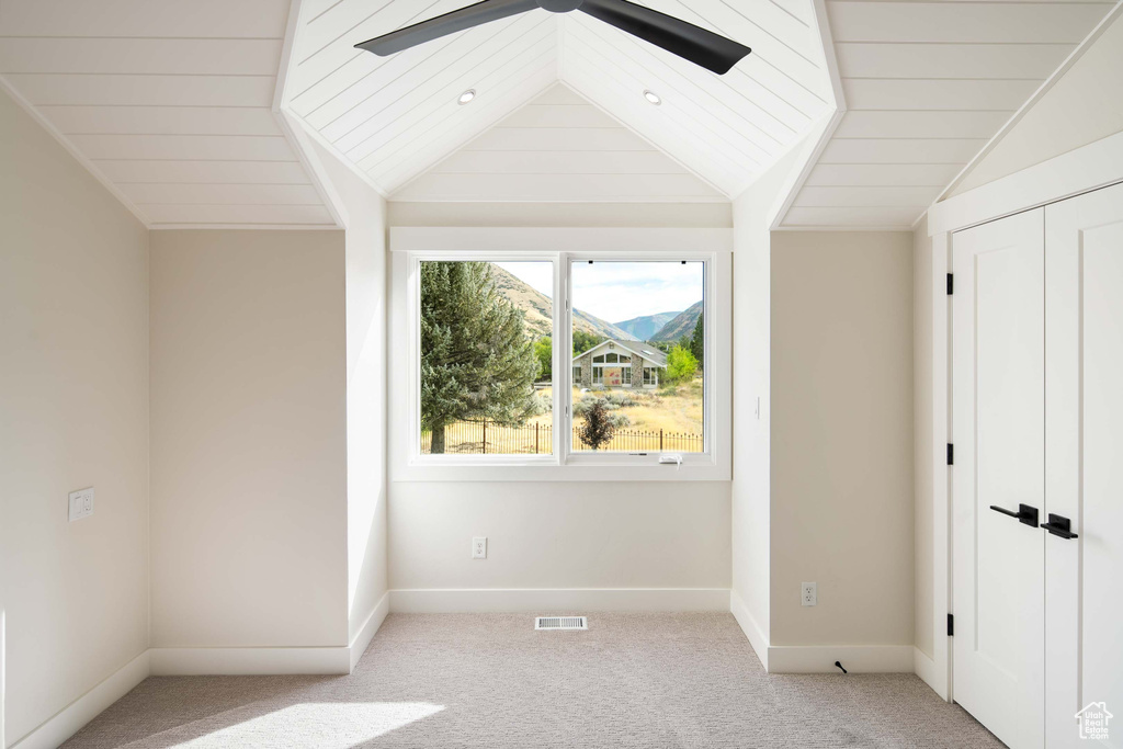 Unfurnished bedroom featuring ceiling fan, light colored carpet, vaulted ceiling, and wooden ceiling