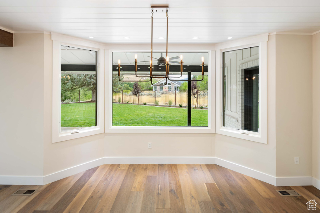 Unfurnished dining area with wood ceiling, a wealth of natural light, a chandelier, and wood-type flooring