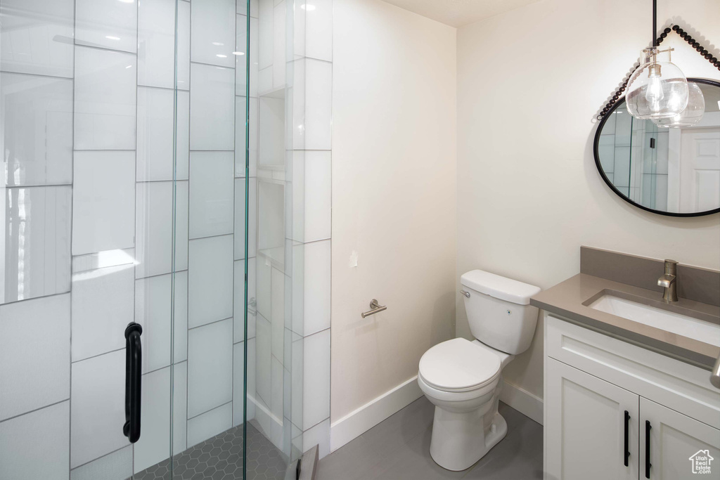 Bathroom featuring vanity, an enclosed shower, and toilet