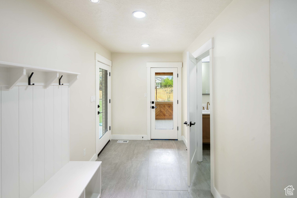 Mudroom featuring a textured ceiling and sink