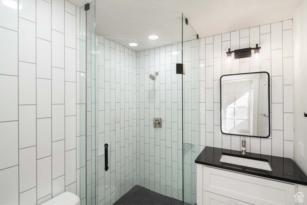 Bathroom with vanity, toilet, and an enclosed shower