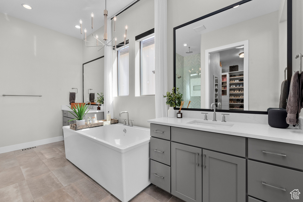 Bathroom featuring a chandelier, independent shower and bath, and vanity