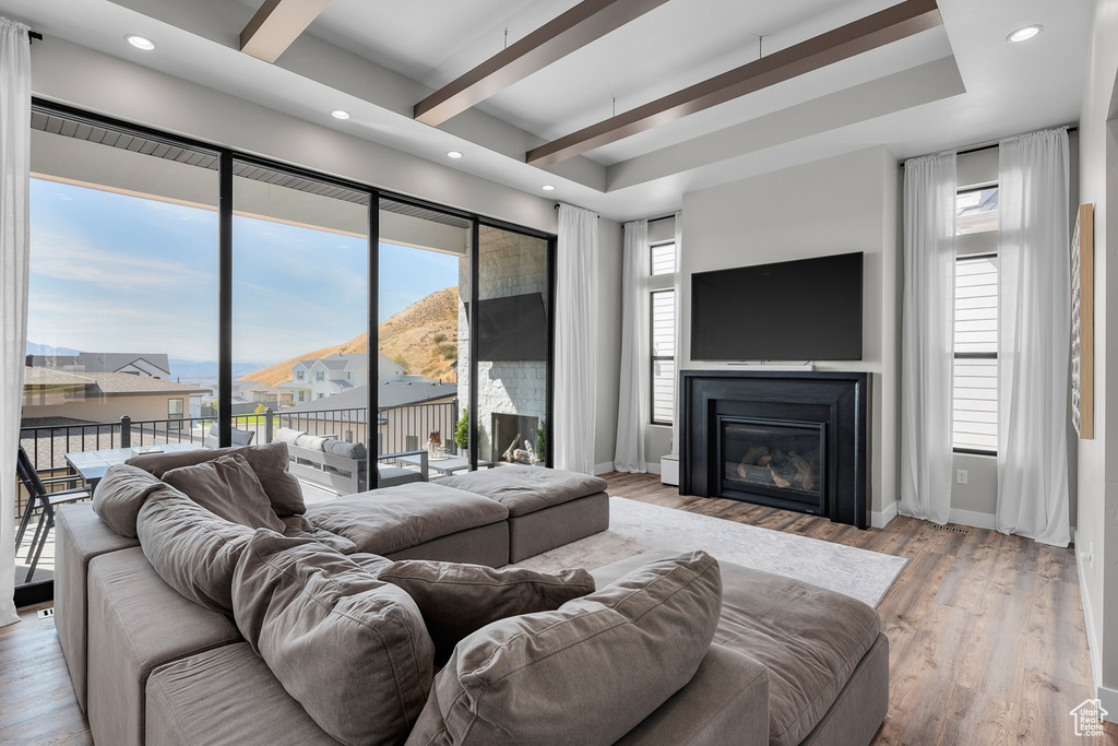 Living room featuring light hardwood / wood-style floors and beamed ceiling