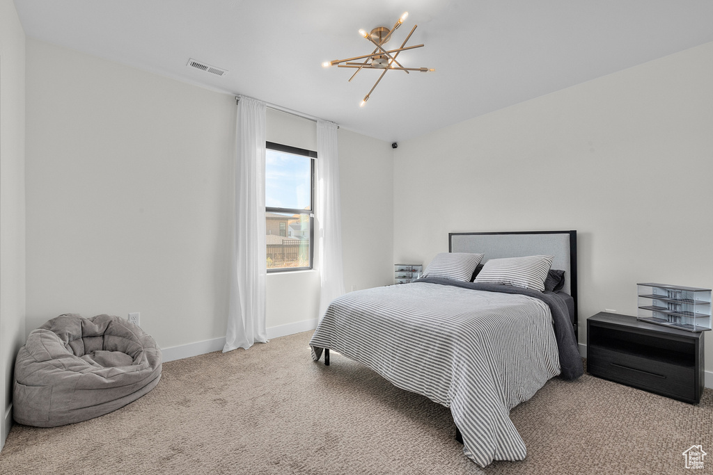 Carpeted bedroom with a notable chandelier