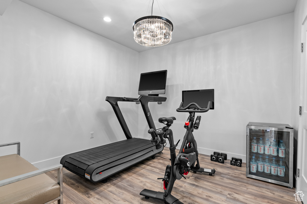 Exercise room featuring wood-type flooring and a chandelier