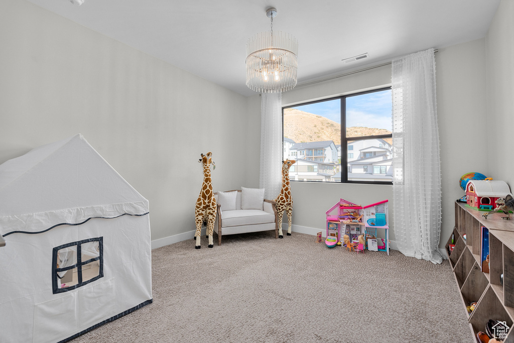 Recreation room with an inviting chandelier, carpet, and a mountain view