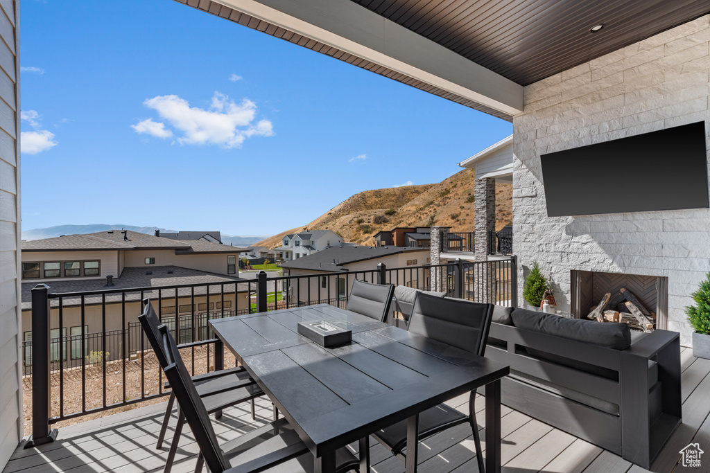 Wooden terrace featuring a mountain view and an outdoor living space with a fireplace