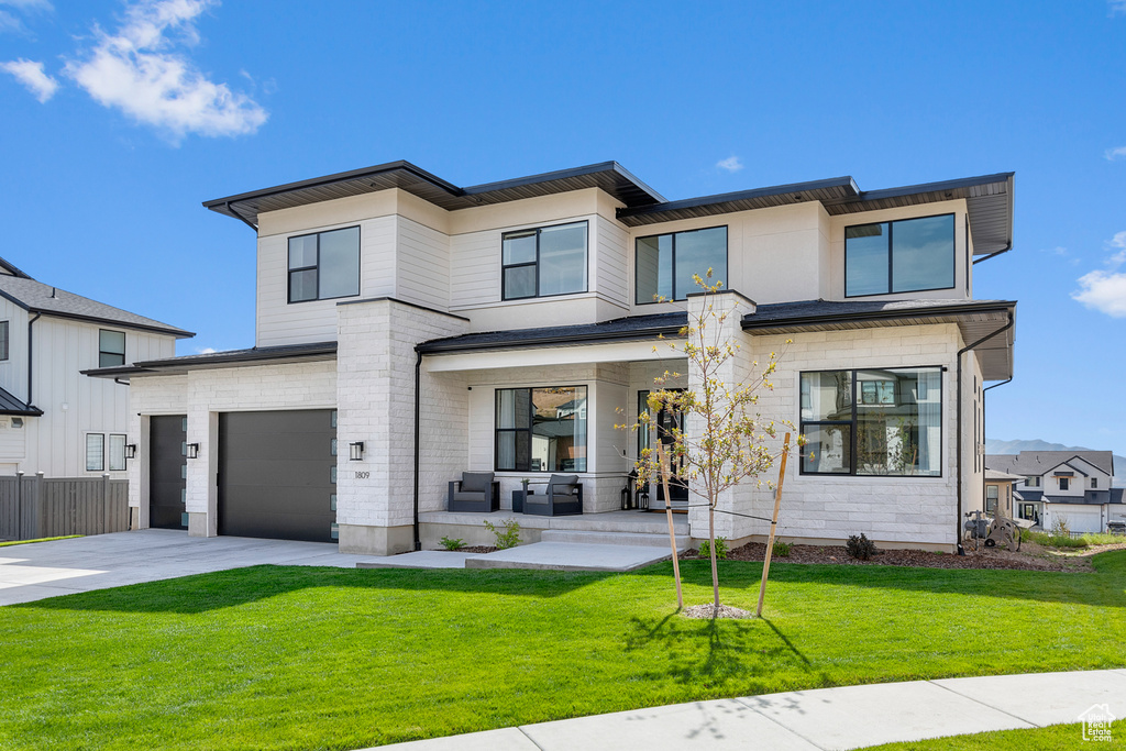 View of front facade with a garage and a front lawn