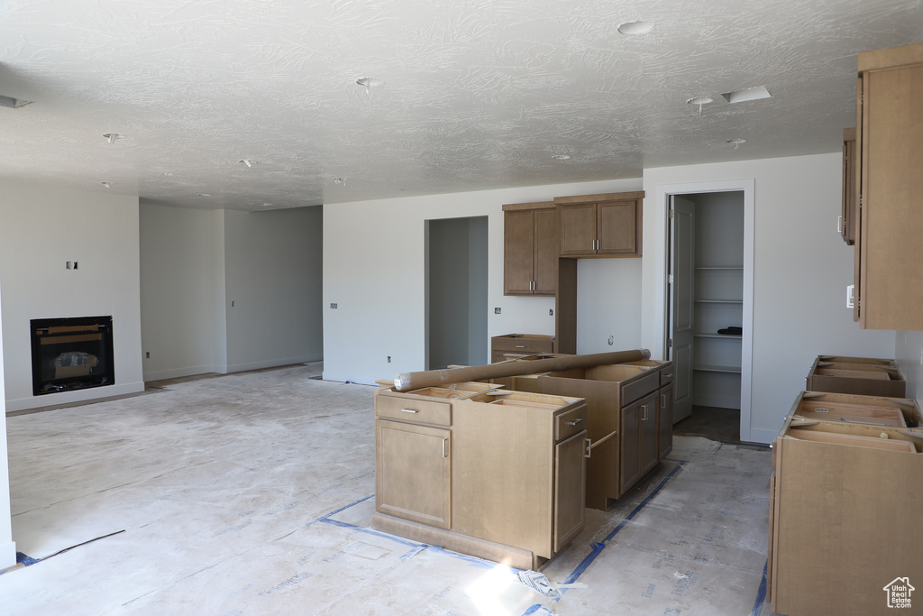 Kitchen featuring a textured ceiling and a center island