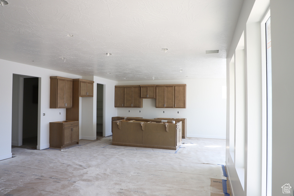 Kitchen featuring a textured ceiling and a kitchen island