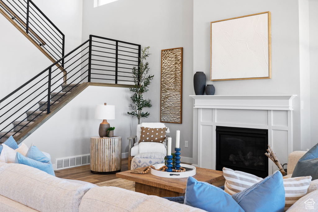 Living room with wood-type flooring and a high ceiling