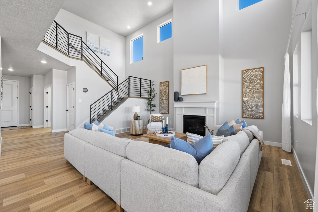 Living room featuring a high ceiling and hardwood / wood-style flooring