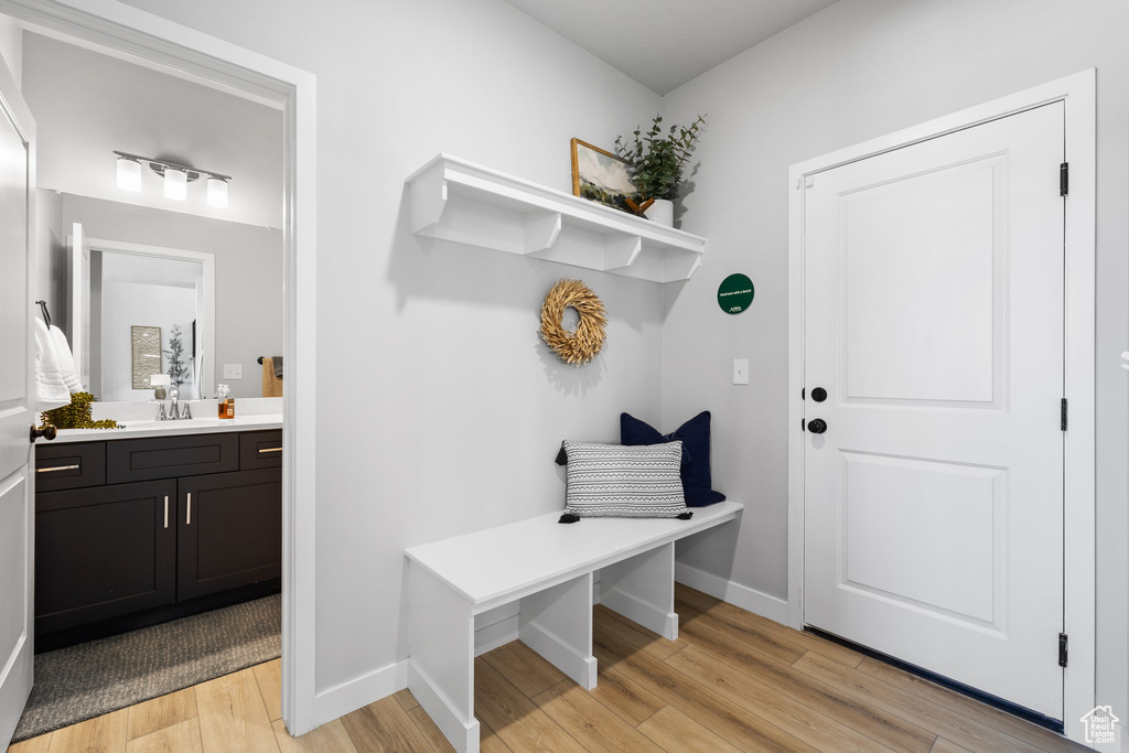 Mudroom with light hardwood / wood-style flooring and sink