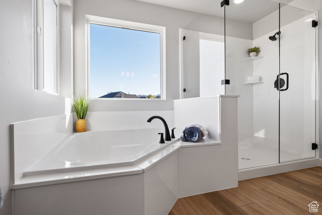 Bathroom featuring plus walk in shower and hardwood / wood-style floors