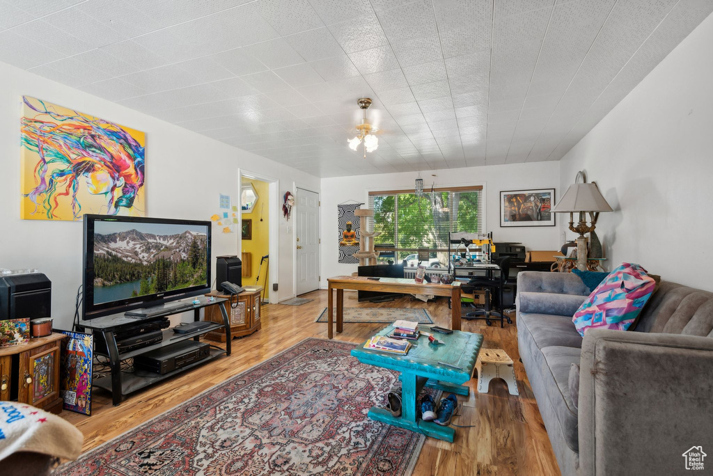 Living room with an inviting chandelier and light wood-type flooring