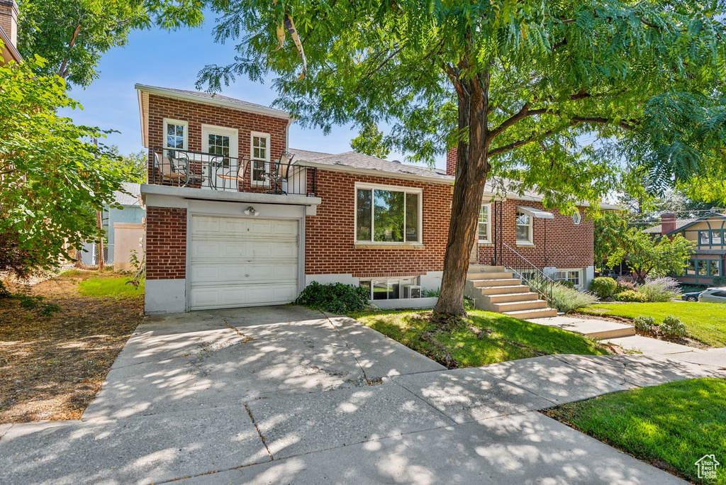 View of front of home featuring a balcony and a garage