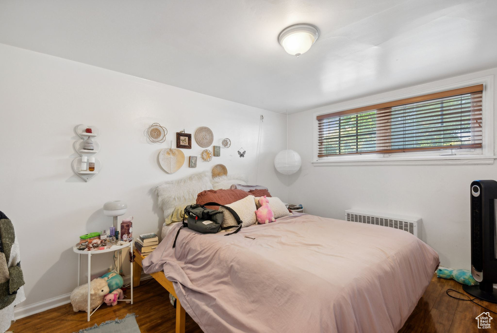 Bedroom featuring dark wood-type flooring and radiator heating unit