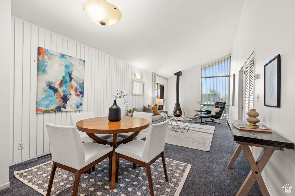 Carpeted dining space featuring a wood stove