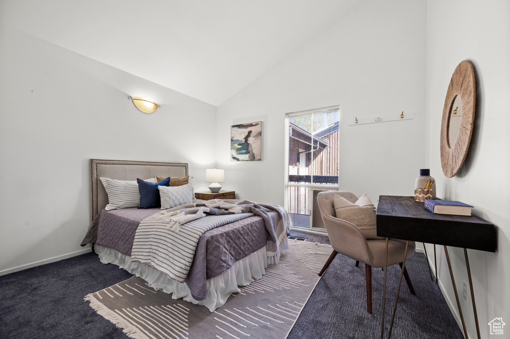 Bedroom featuring dark carpet and high vaulted ceiling