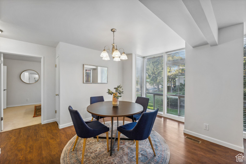 Dining area with an inviting chandelier, dark hardwood / wood-style flooring, and a wealth of natural light