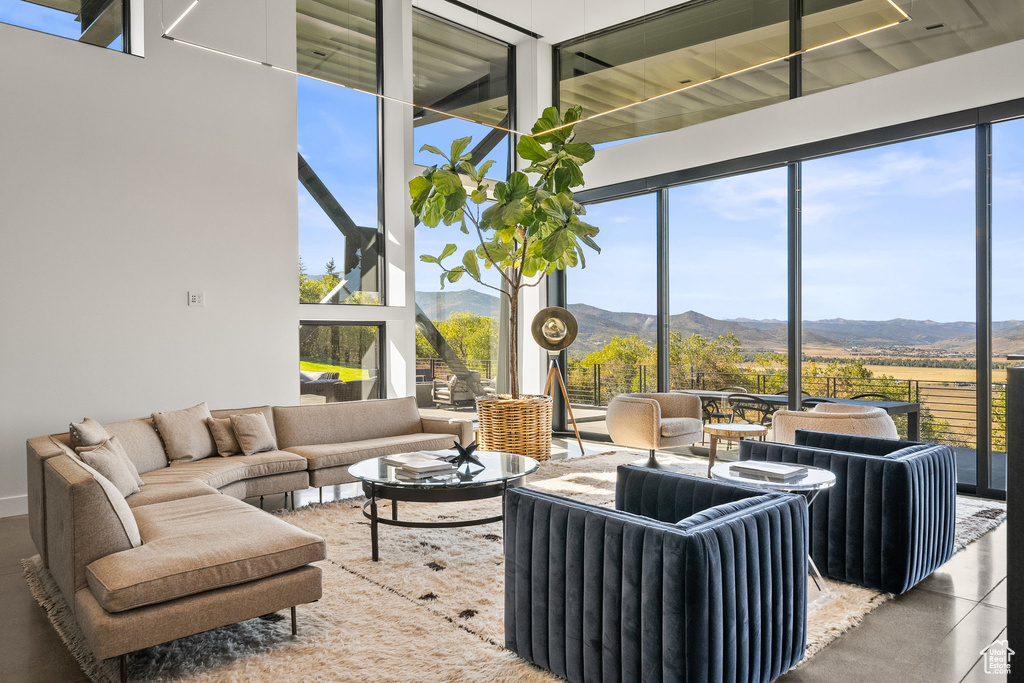Living area with a mountain view, healthy amount of natural light, and a wall of windows